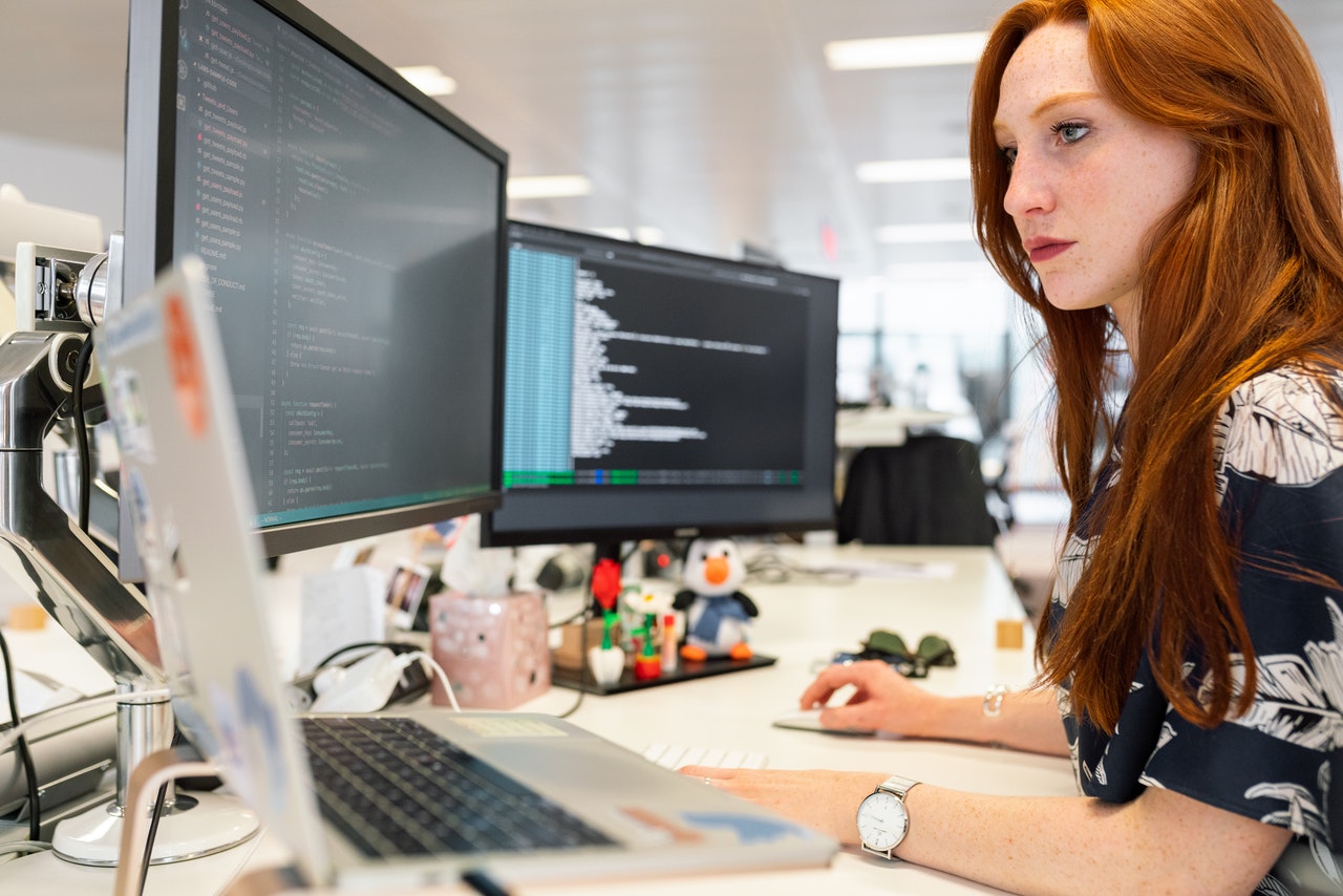 Developer at workstation with multiple screens